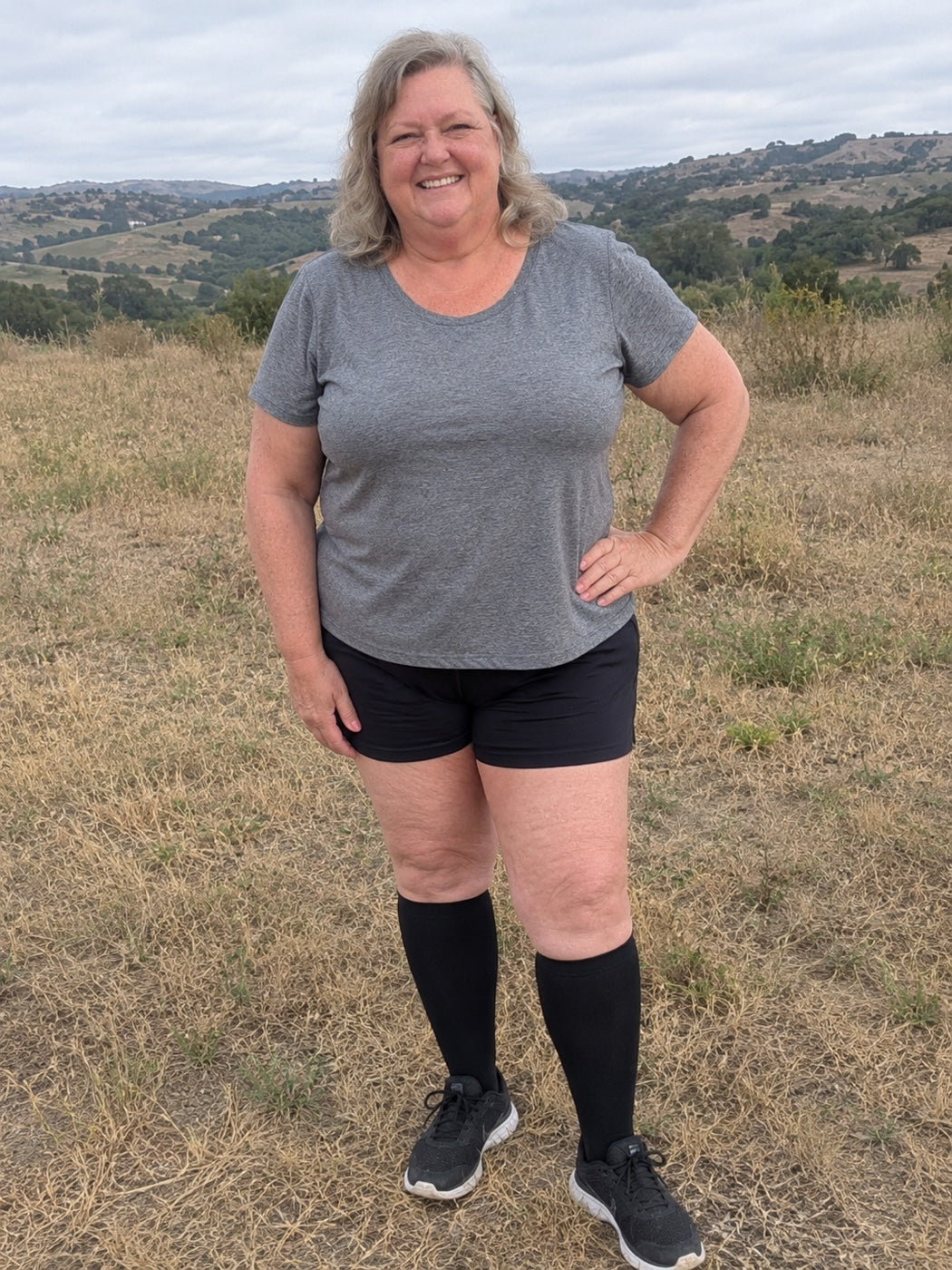 Woman standing outdoors in Comfyso Bamboo compression socks in Classic Black, staying up smoothly below the knee.